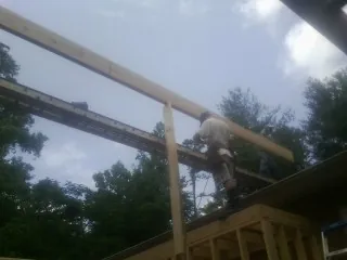 Carpenter setting a ridge beam over a new addition frame — Ice Dam Removal by Roofing Brothers in Boling