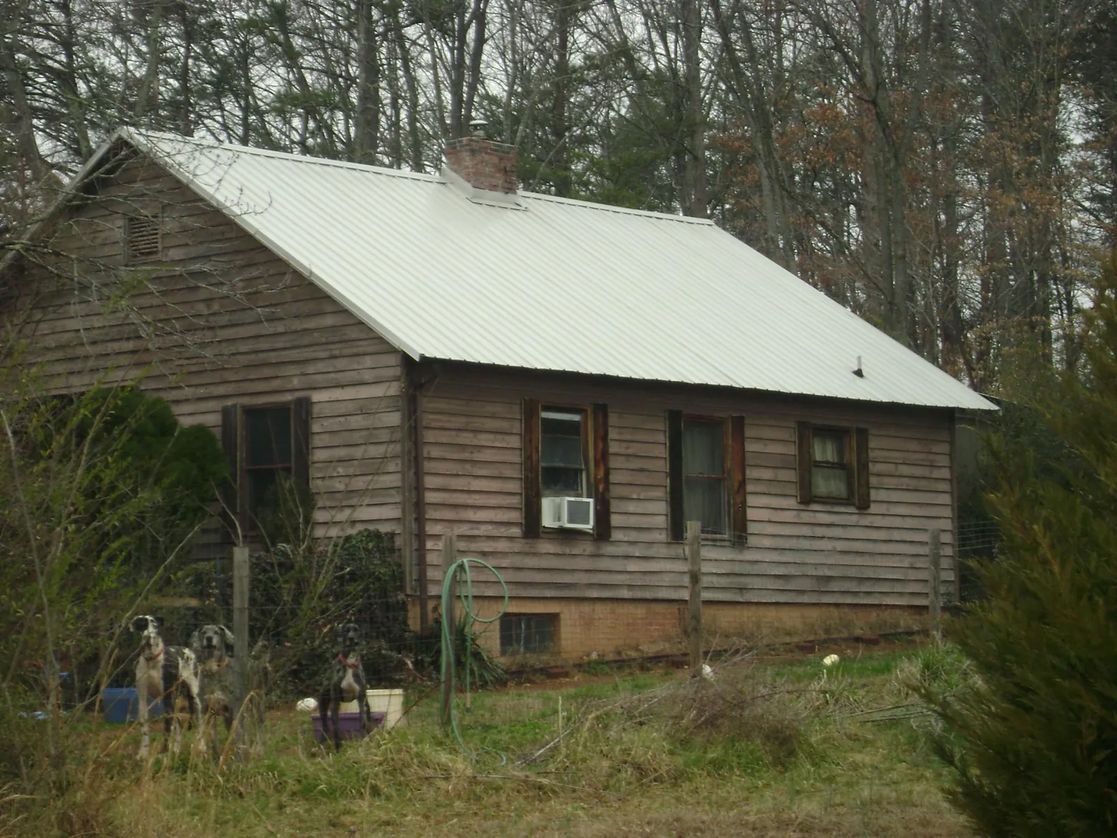 White metal roof on an old wood sided farmhouse, from a Metal Roof Installation job in Boling